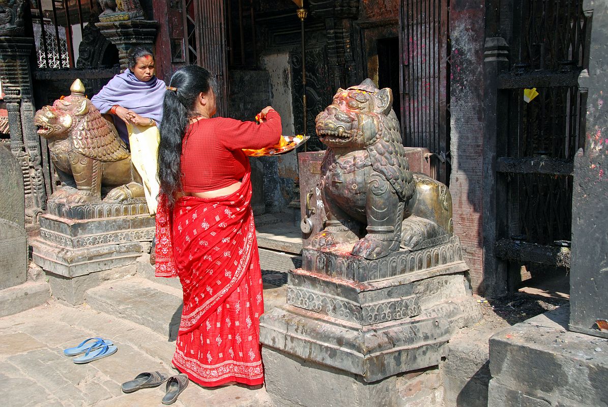 Kathmandu Valley 2 Kirtipur 05 Bagh Bhairav Temple Pilgrims At Entrance A pilgrim makes offerings at the entrance to the Bagh Bhairav Temple in Kirtipur near Kathmandu.